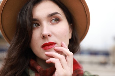 Photo of Beautiful woman in hat with red lips outdoors