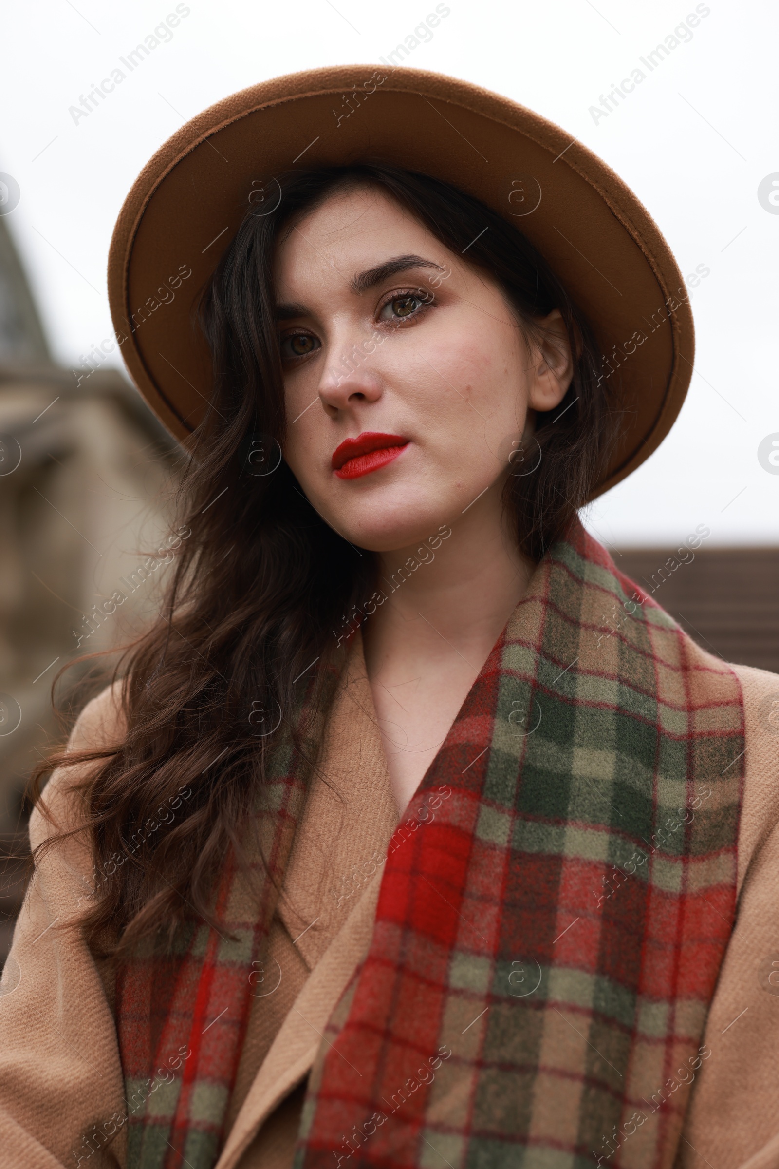 Photo of Beautiful woman with hat and scarf on city street