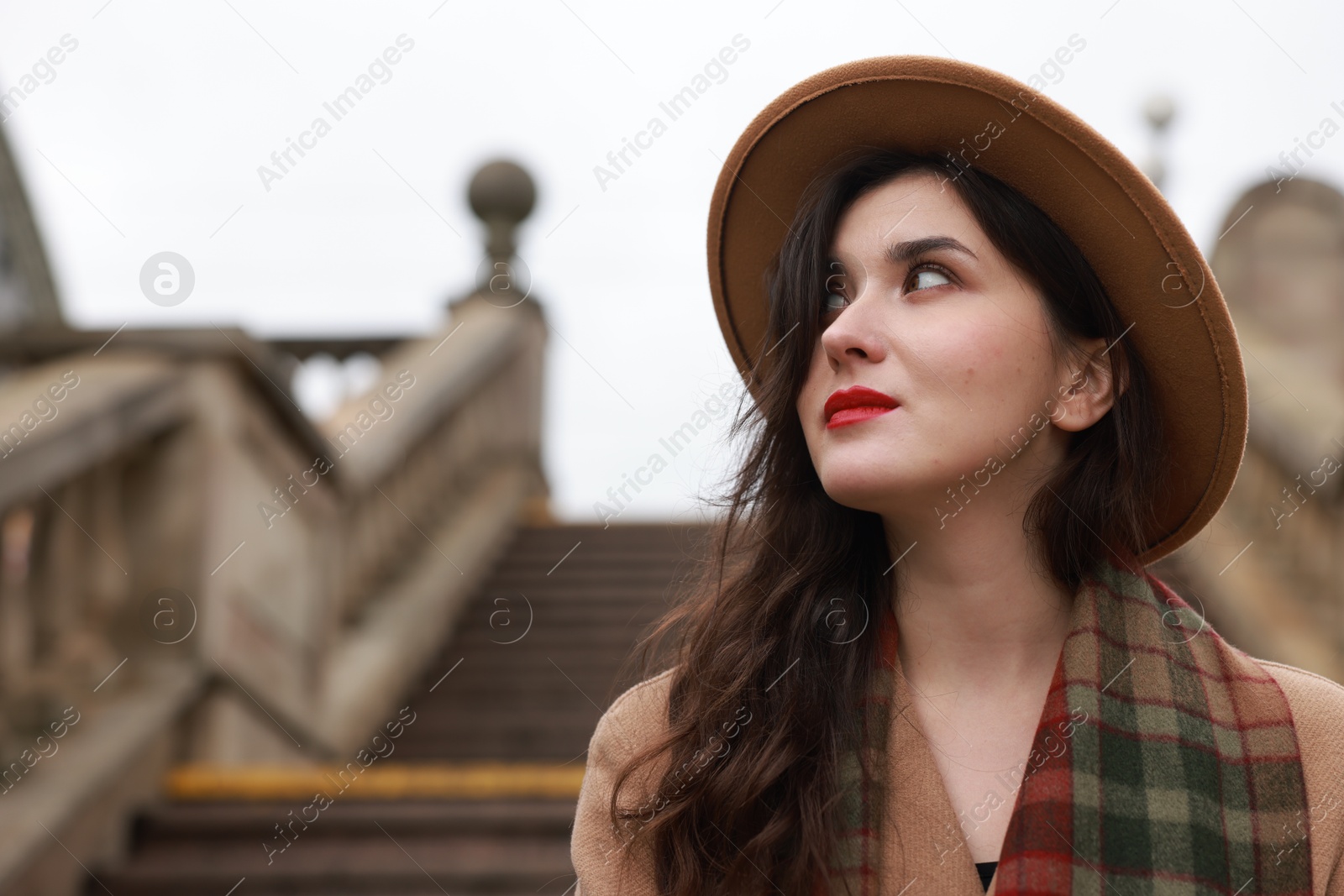 Photo of Beautiful woman with suitcase near stairs outdoors. space for text