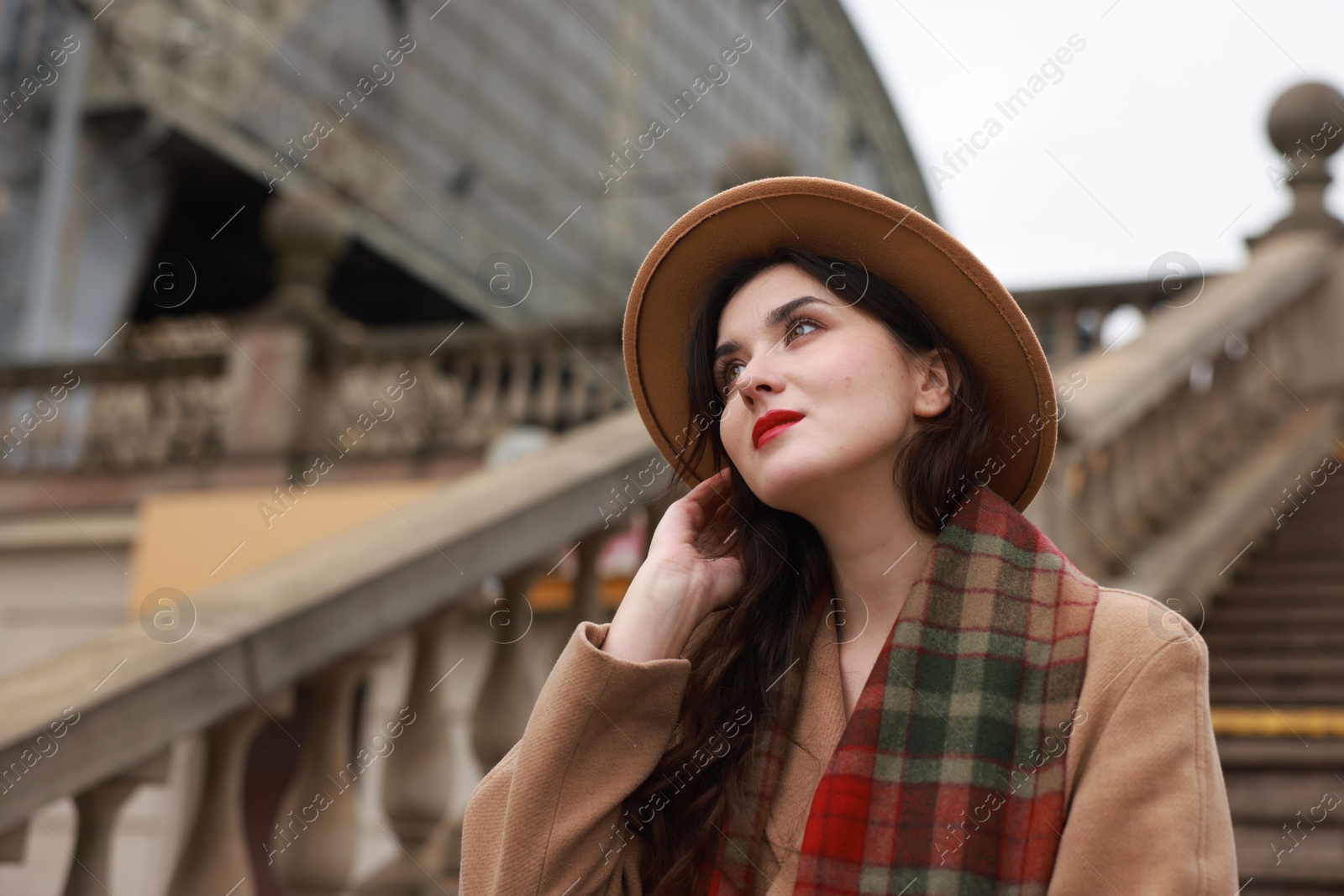 Photo of Beautiful woman with suitcase near stairs outdoors