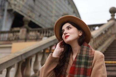 Photo of Beautiful woman with suitcase near stairs outdoors