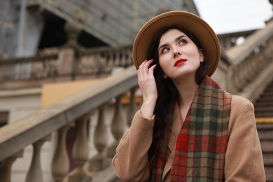 Photo of Beautiful woman with suitcase near stairs outdoors