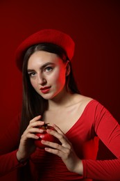 Photo of Woman with ripe pomegranate on red background