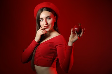 Photo of Woman with ripe pomegranate on red background