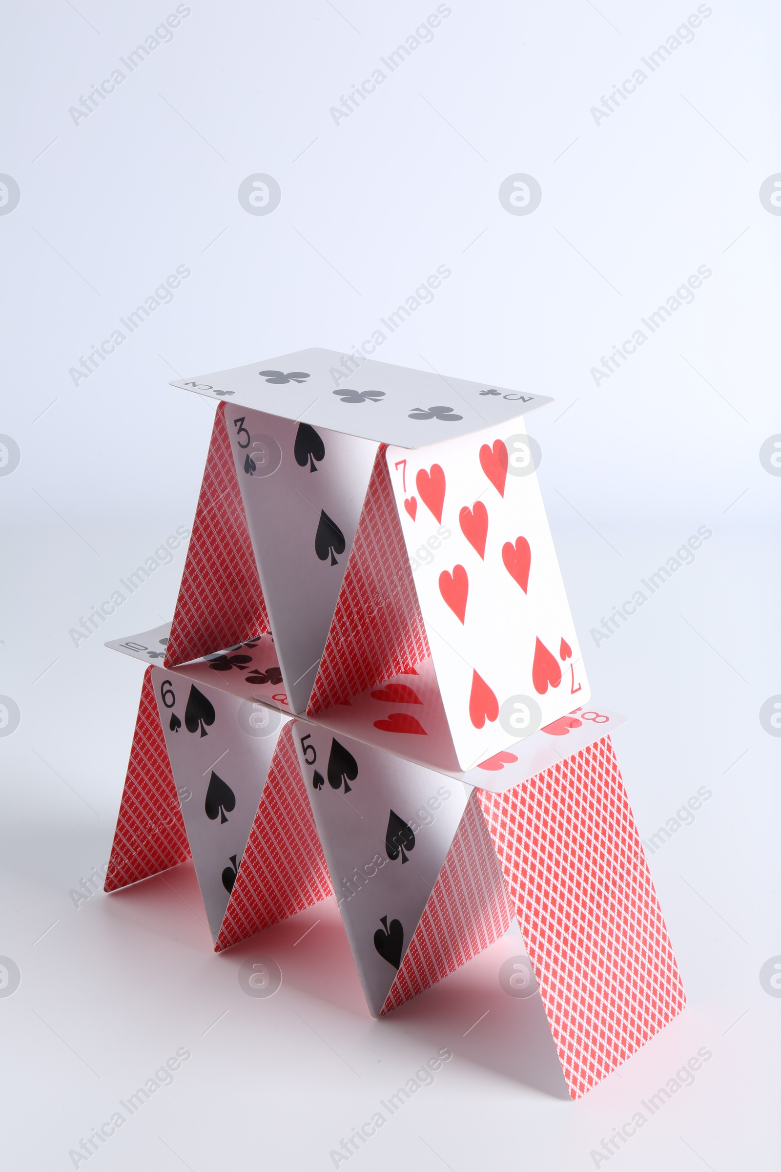 Photo of House of playing cards on white background