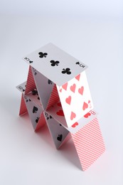 Photo of House of playing cards on white background