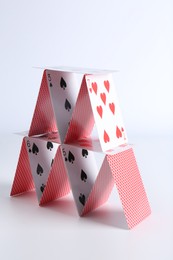 Photo of House of playing cards on white background