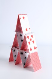 Photo of House of playing cards on white background