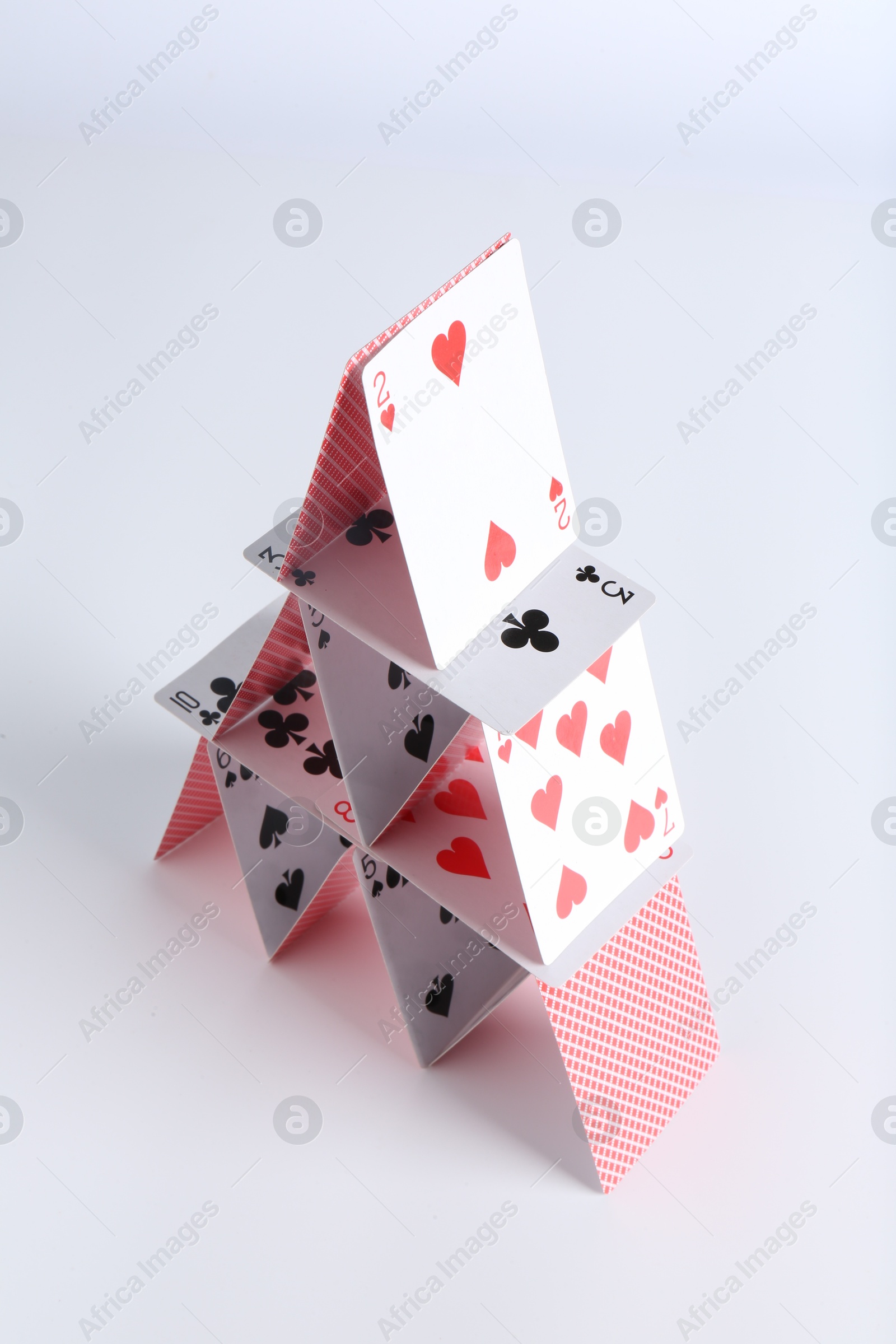 Photo of House of playing cards on white background