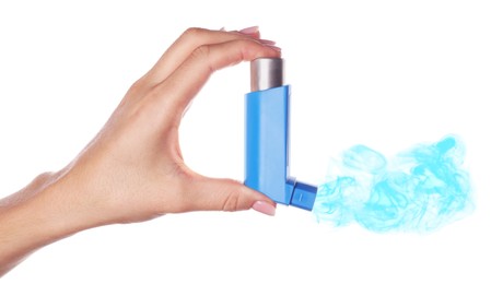 Asthma treatment. Woman holding inhaler on white background, closeup. Aerosolized medication coming out of device