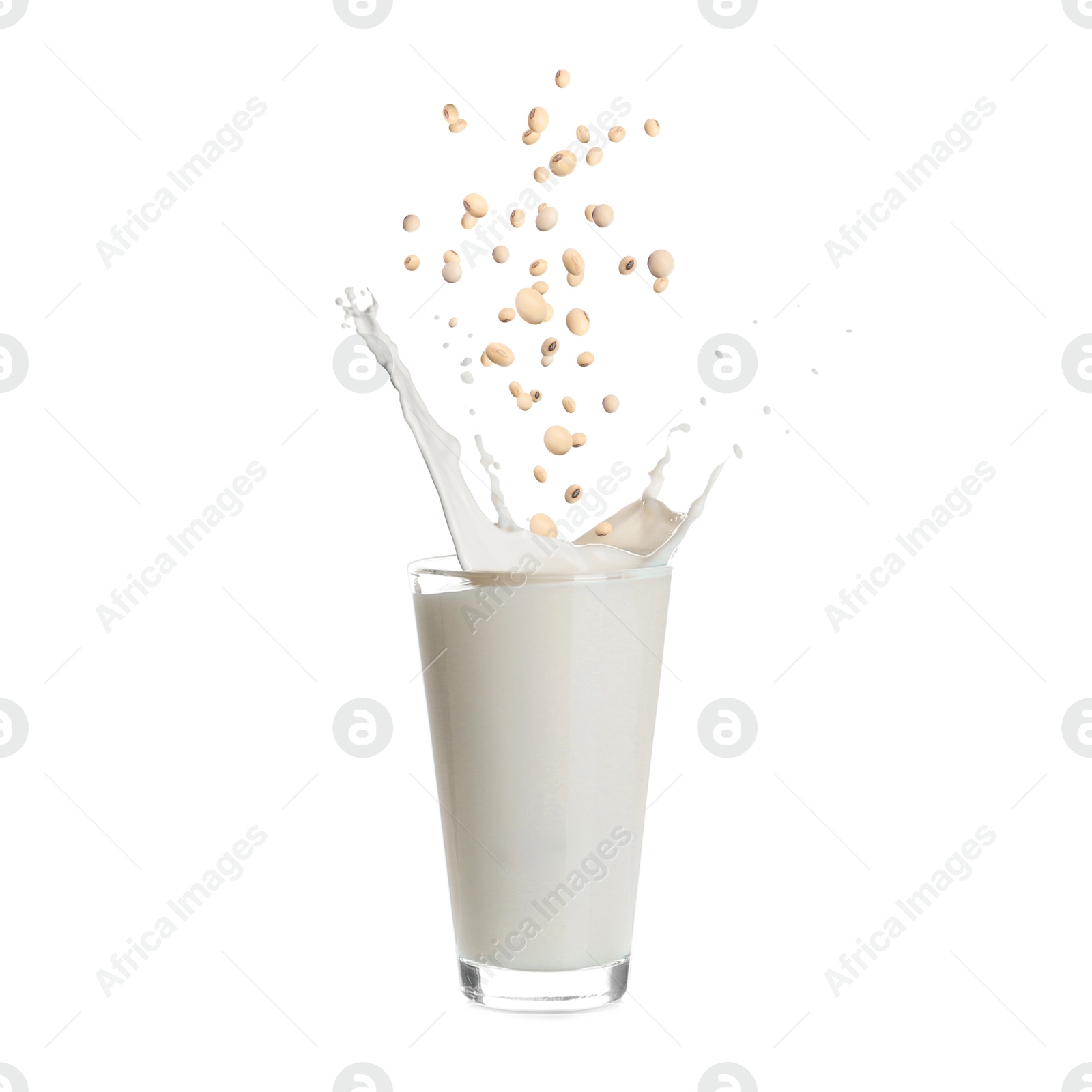 Image of Soy beans falling into glass of plant milk on white background