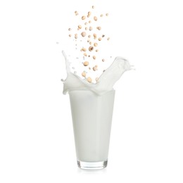 Image of Soy beans falling into glass of plant milk on white background