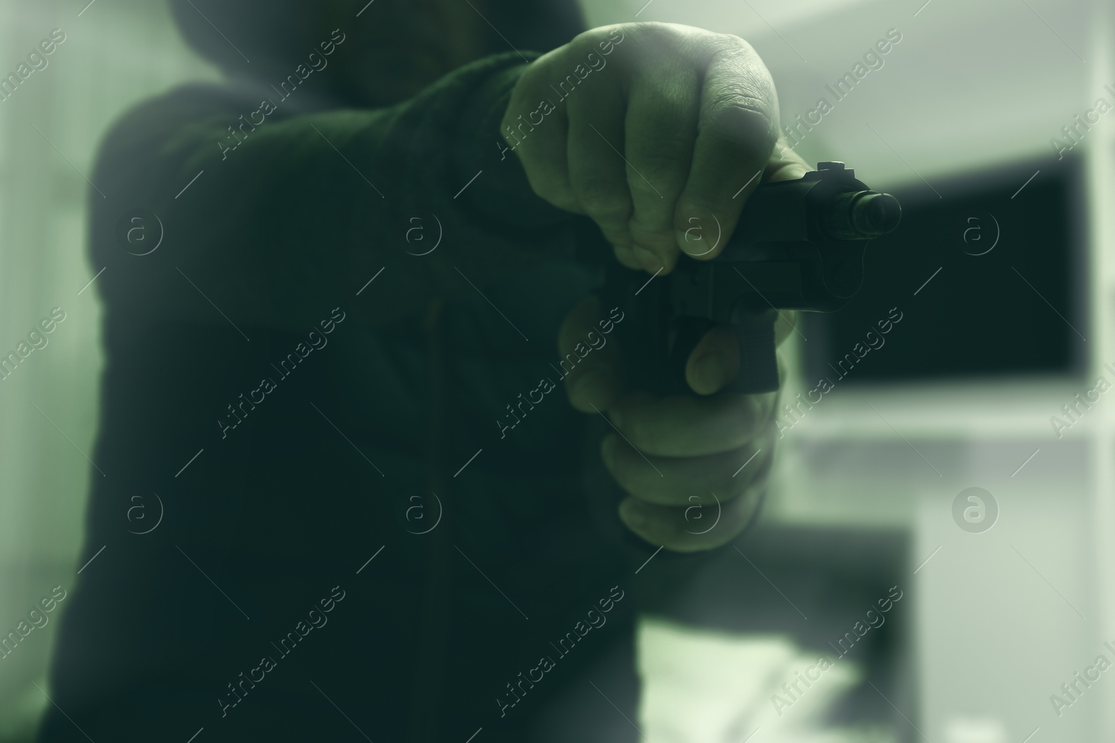 Image of Dangerous criminal with gun indoors, selective focus. Armed robbery