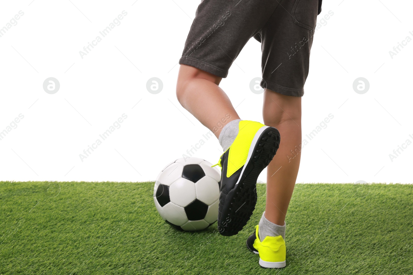 Photo of Football player with soccer ball on artificial grass against white background, closeup