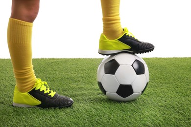 Football player with soccer ball on artificial grass against white background, closeup