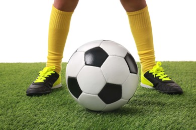 Football player with soccer ball on artificial grass against white background, closeup