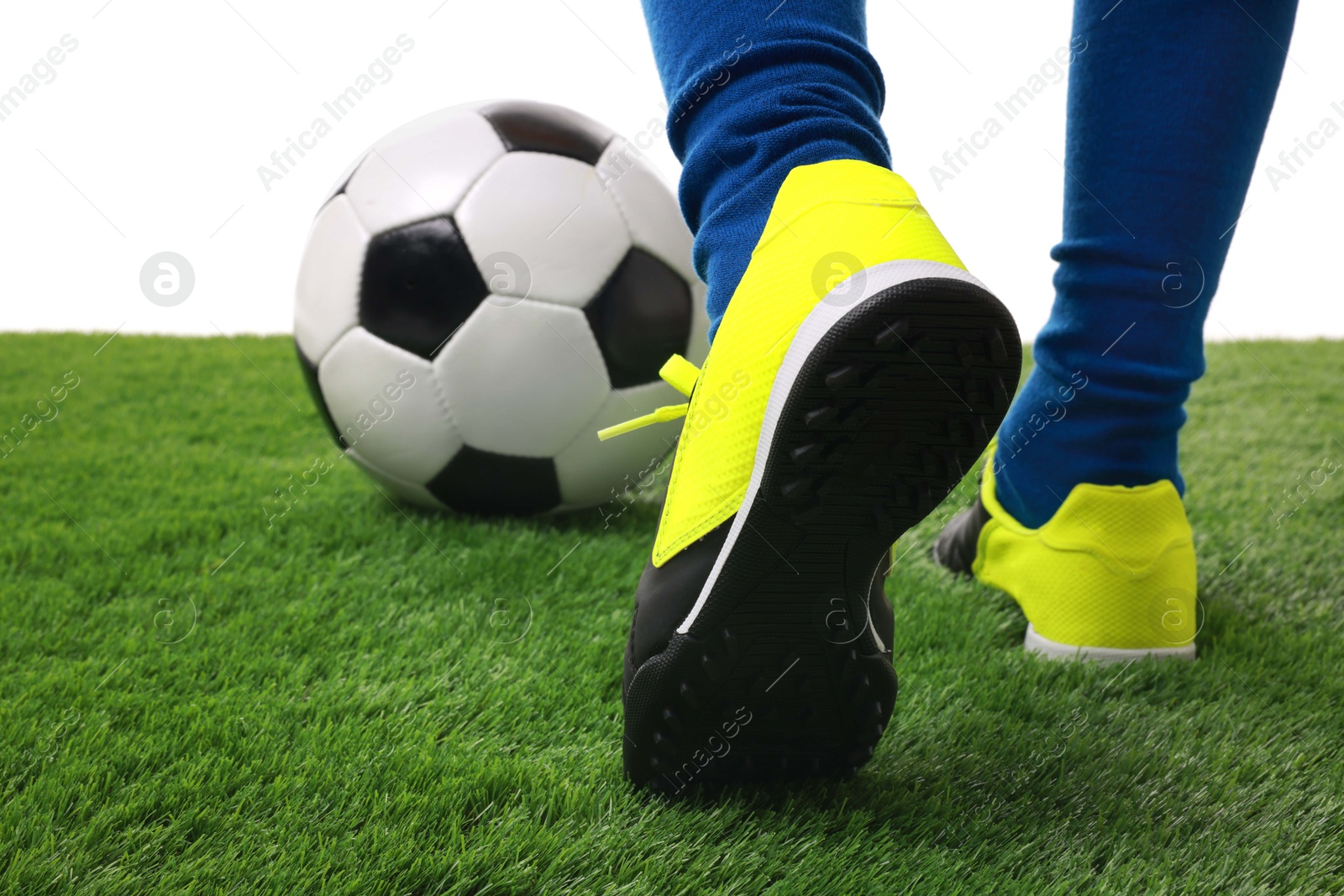 Photo of Boy with soccer ball playing football on artificial grass against white background, closeup