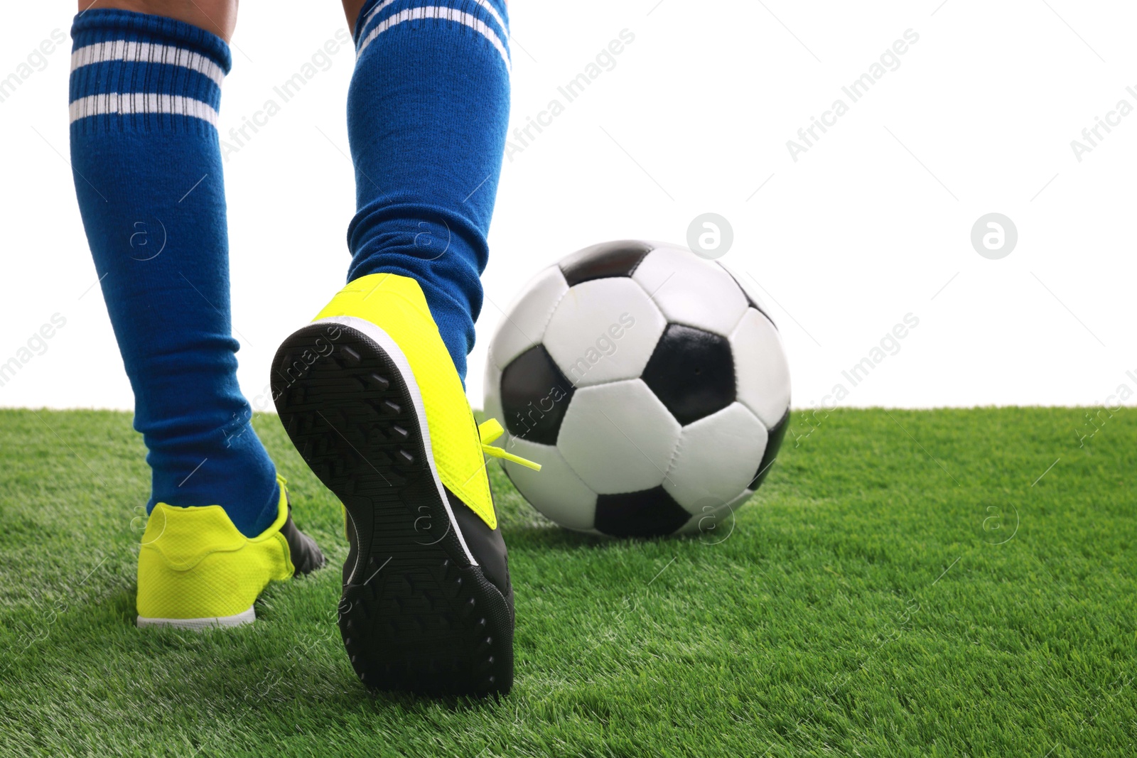 Photo of Boy with soccer ball playing football on artificial grass against white background, closeup