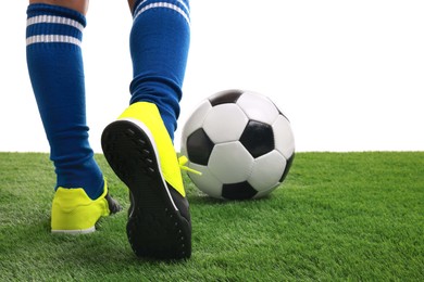 Photo of Boy with soccer ball playing football on artificial grass against white background, closeup