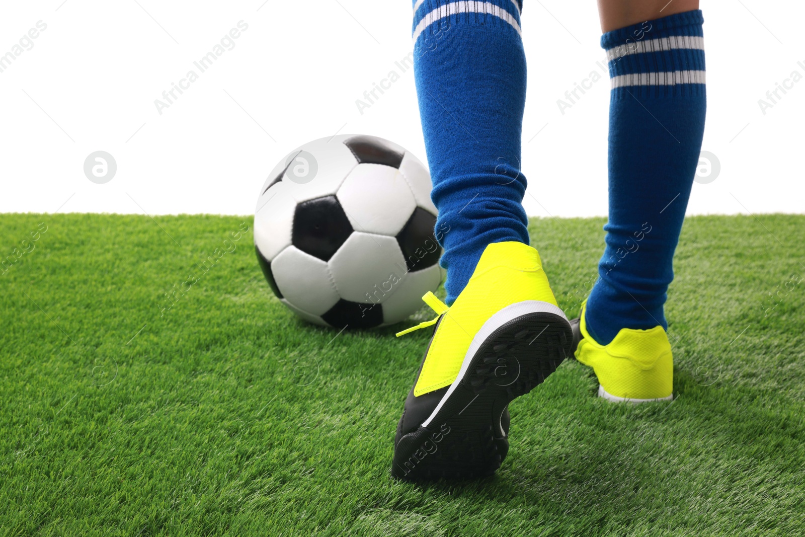 Photo of Boy with soccer ball playing football on artificial grass against white background, closeup