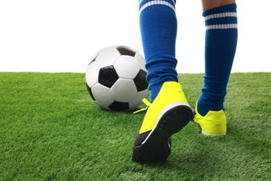 Photo of Boy with soccer ball playing football on artificial grass against white background, closeup