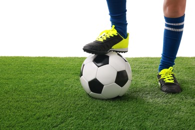 Photo of Football player with soccer ball on artificial grass against white background, closeup