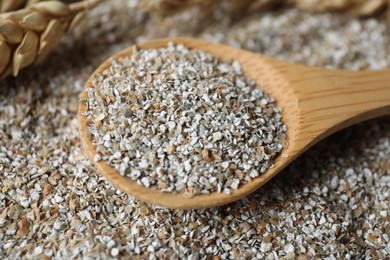 Photo of Wooden spoon with fresh rye bran, closeup