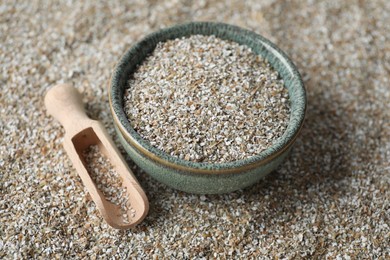 Photo of Bowl and scoop with fresh rye bran, closeup