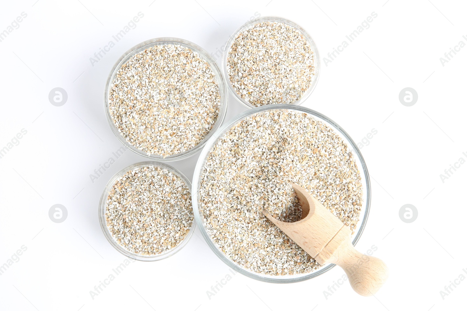 Photo of Fresh rye bran in bowls and scoop on white background, top view