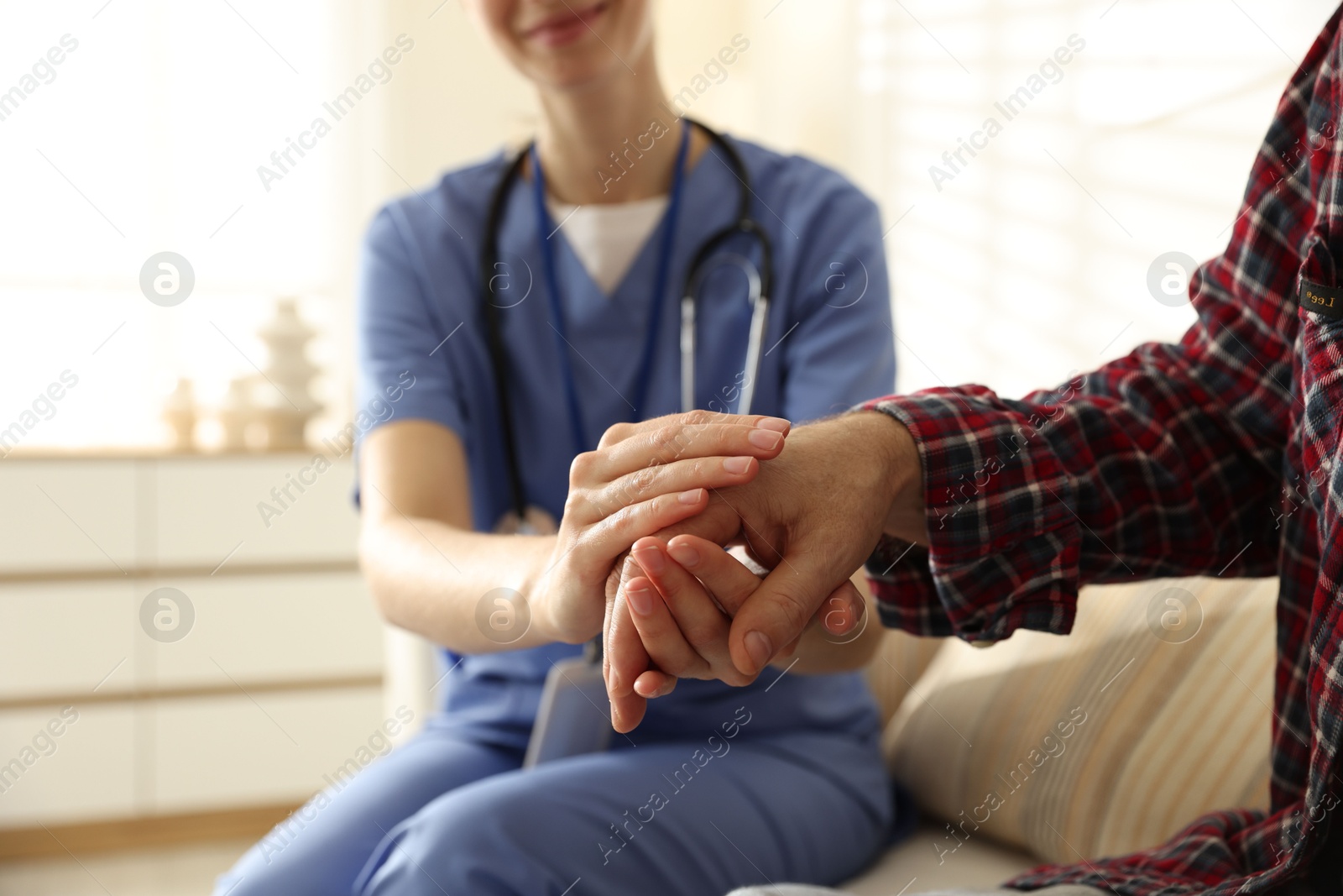 Photo of Caregiver supporting senior woman indoors, closeup. Home health care service