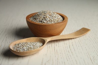 Photo of Fresh rye bran in bowl and spoon on light wooden table, closeup