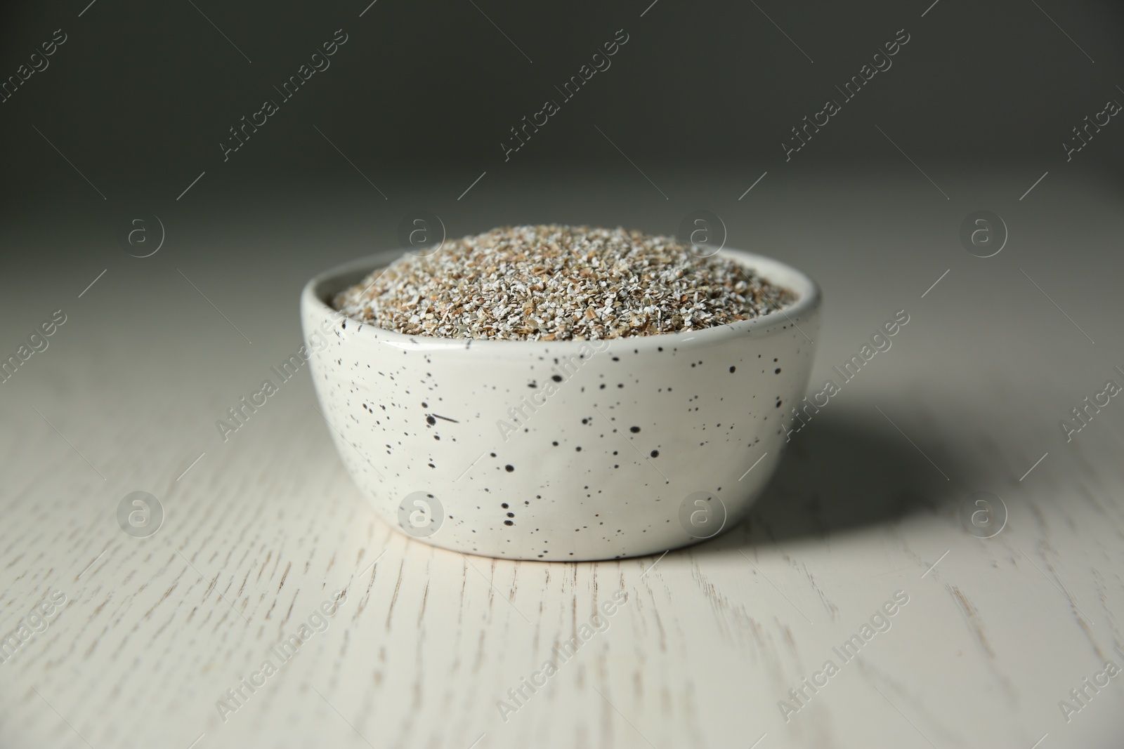 Photo of Fresh rye bran in bowl on light wooden table