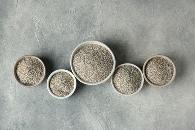 Photo of Fresh rye bran in bowls on grey textured table, flat lay