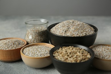 Photo of Fresh rye bran and kernels on grey textured table, closeup