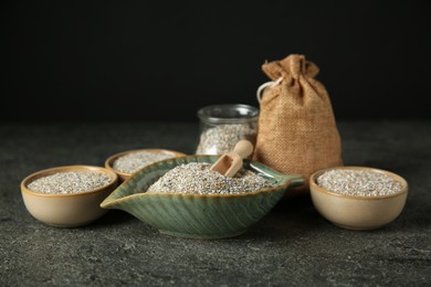 Photo of Fresh rye bran and scoop on grey textured table