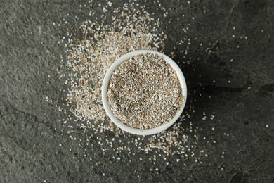 Photo of Fresh rye bran in bowl on grey textured table, top view