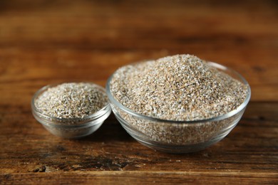 Photo of Fresh rye bran in bowls on wooden table, closeup