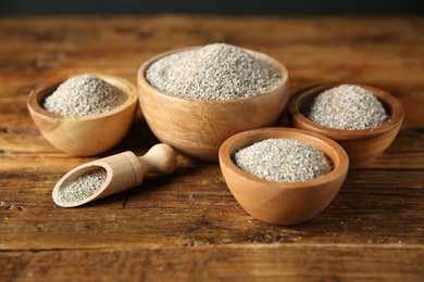 Photo of Fresh rye bran in bowls and scoop on wooden table, closeup