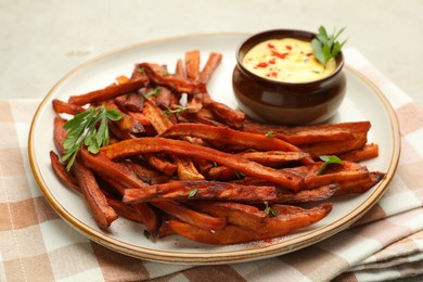 Photo of Delicious sweet potato fries with sauce on light table, closeup