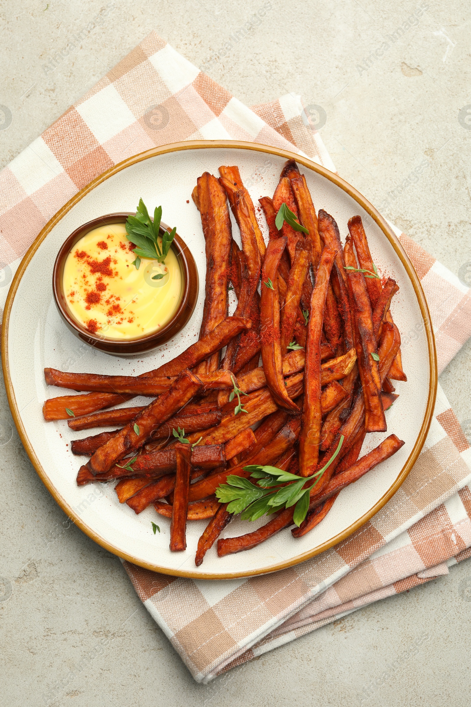 Photo of Delicious sweet potato fries with sauce on light table, top view