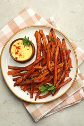 Delicious sweet potato fries with sauce on light table, top view