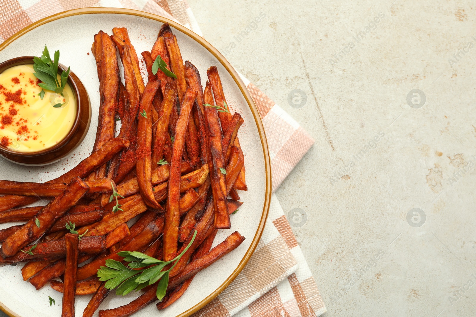 Photo of Delicious sweet potato fries with sauce on light table, top view. Space for text