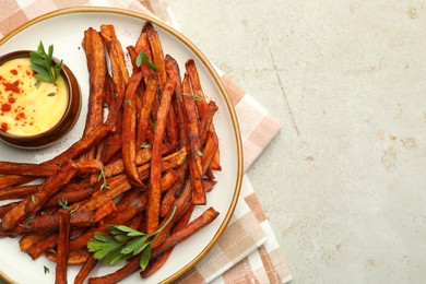 Photo of Delicious sweet potato fries with sauce on light table, top view. Space for text