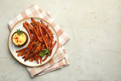 Photo of Delicious sweet potato fries with sauce on light table, top view. Space for text