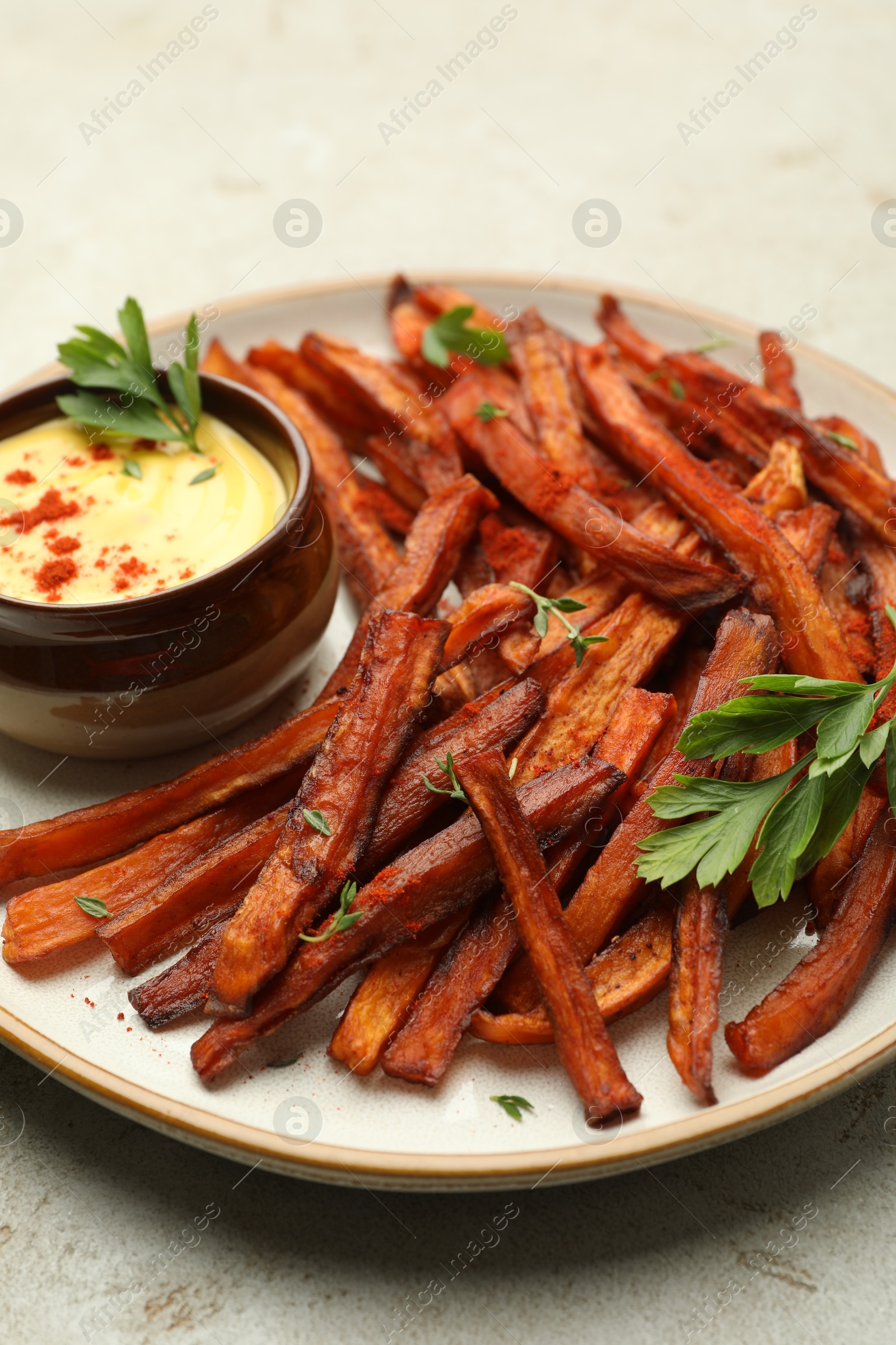 Photo of Delicious sweet potato fries with sauce on light table, closeup