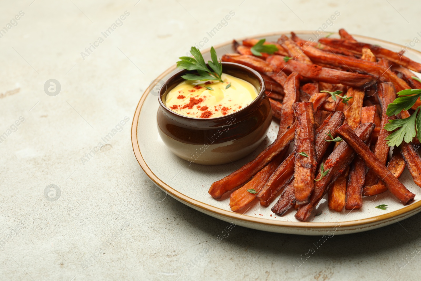 Photo of Delicious sweet potato fries with sauce on light table, closeup