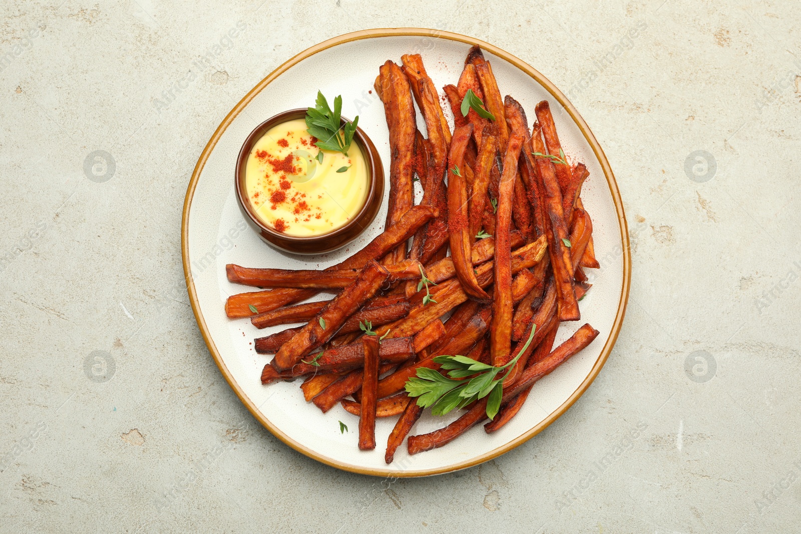 Photo of Delicious sweet potato fries with sauce on light table, top view