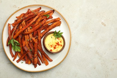 Photo of Delicious sweet potato fries with sauce on light table, top view. Space for text