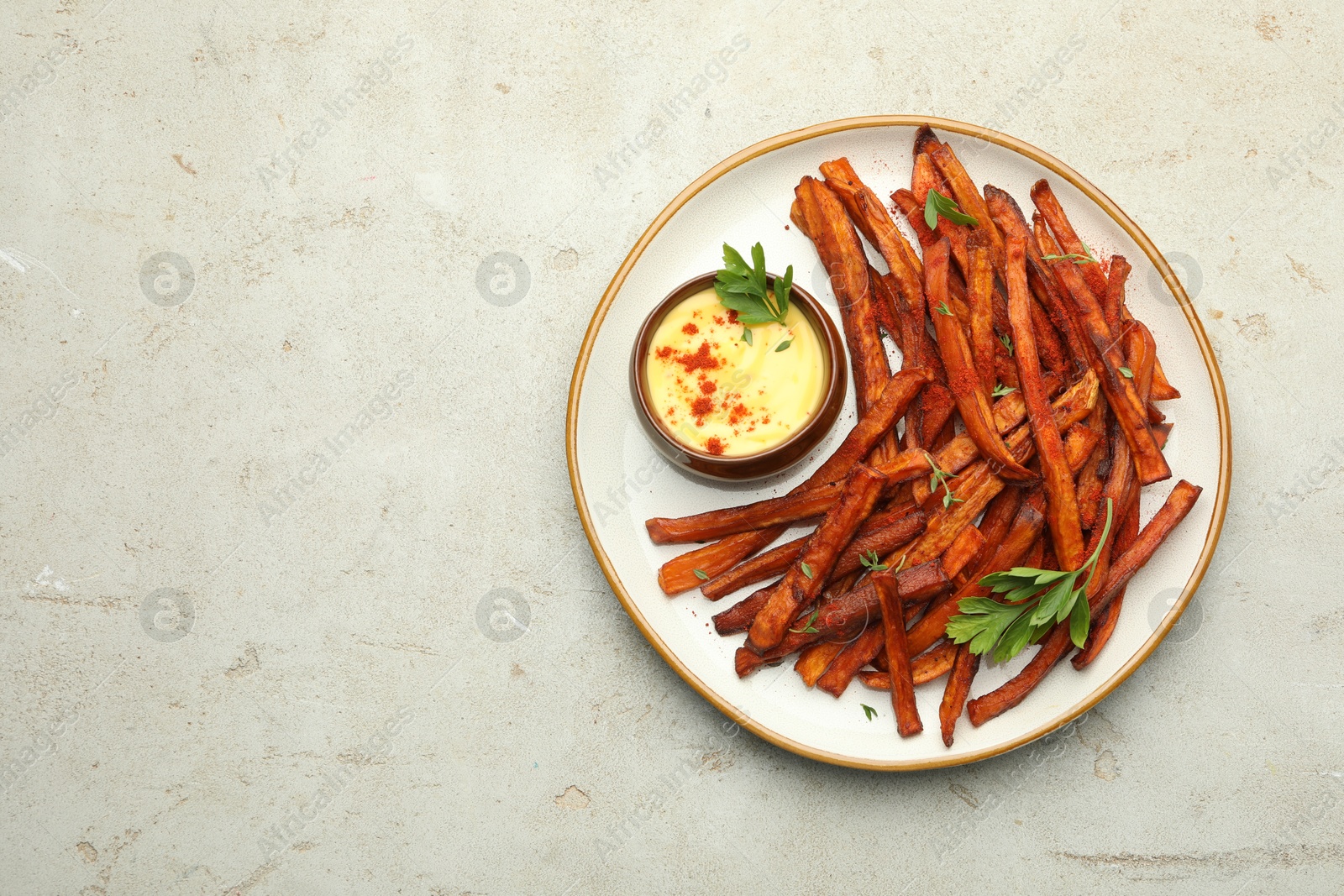 Photo of Delicious sweet potato fries with sauce on light table, top view. Space for text