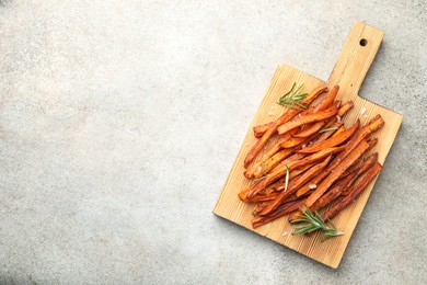 Delicious sweet potato fries with spices on grey table, top view. Space for text